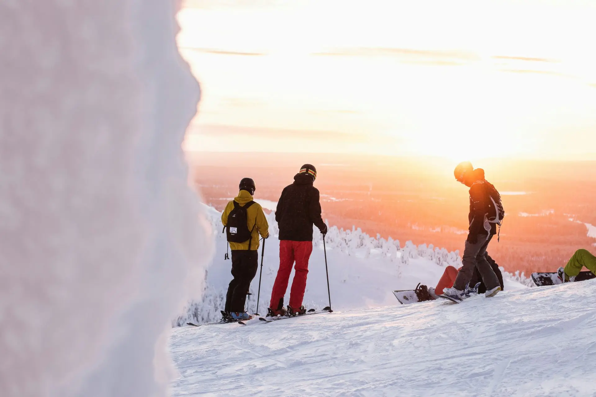 Skifahrer:innen und Snowboarder:innen auf der Piste mit Sonnenuntergang im Hintergrund - Sport & Outdoor Schädlich in Aschaffenburg